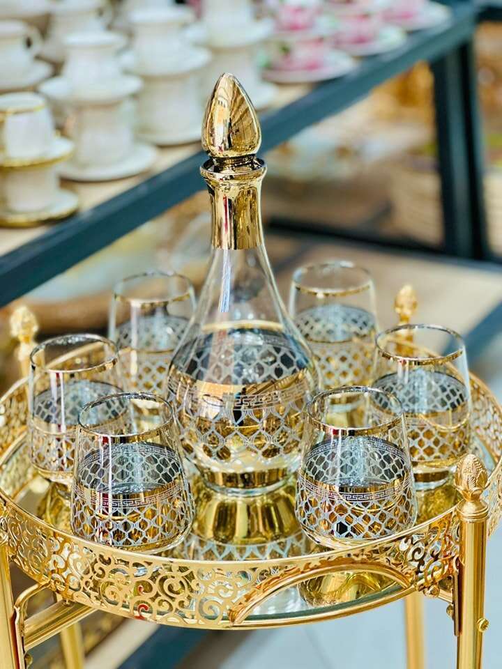 shaker doré, carafe en verre, verres élégants avec cocktail et